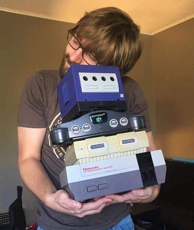 John holding his retro Nintendo consoles.